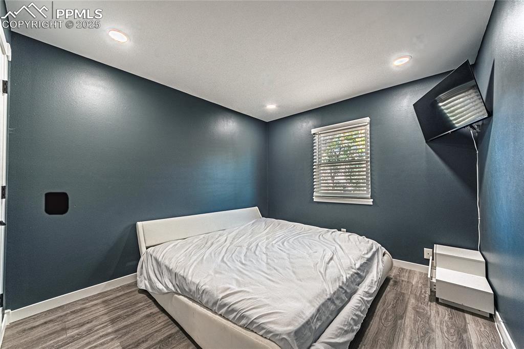 Image 24 of 46: Bedroom with dark wood-style floors and recessed lighting