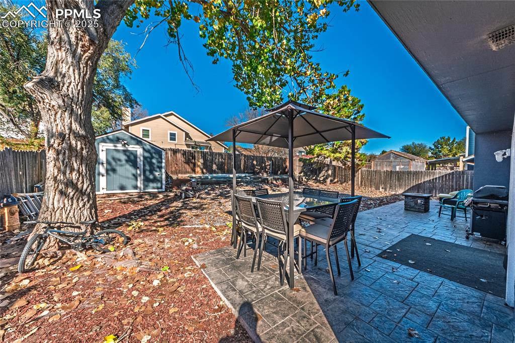 Image 29 of 46: Fenced backyard featuring outdoor dining space, a patio area, a shed, an ou