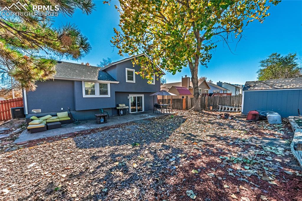 Image 33 of 46: Back of property with a fenced backyard, a patio, roof with shingles, and s
