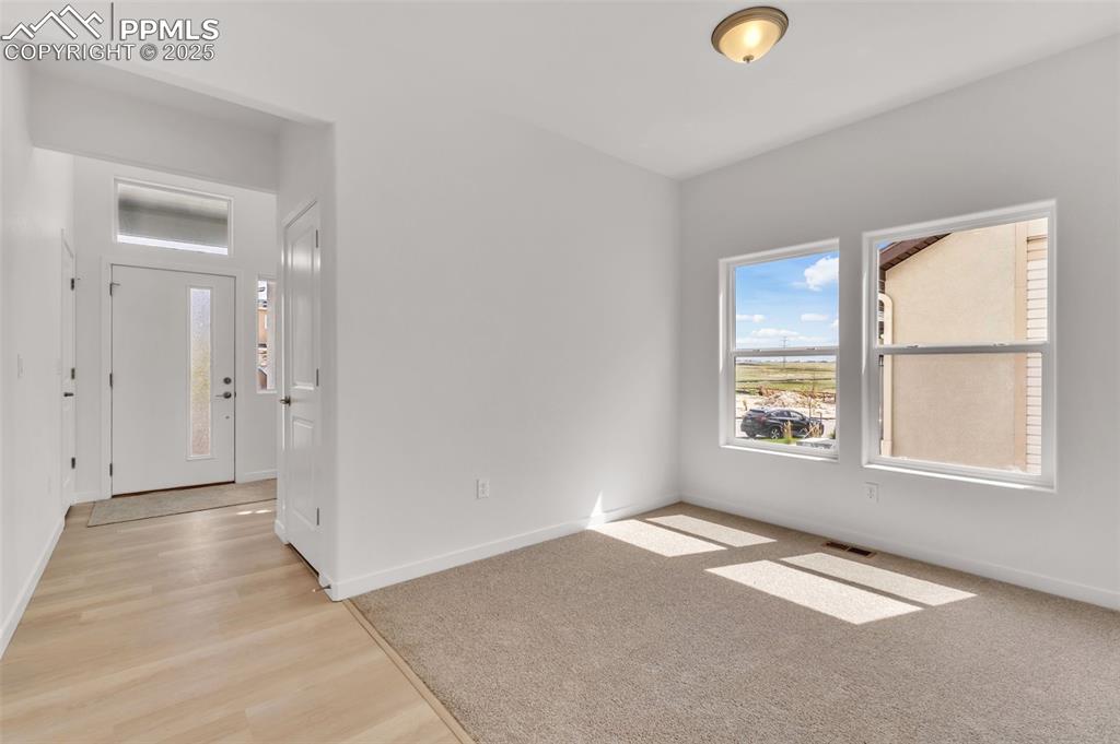 Image 24 of 43: Spare room with light wood-style flooring and light carpet