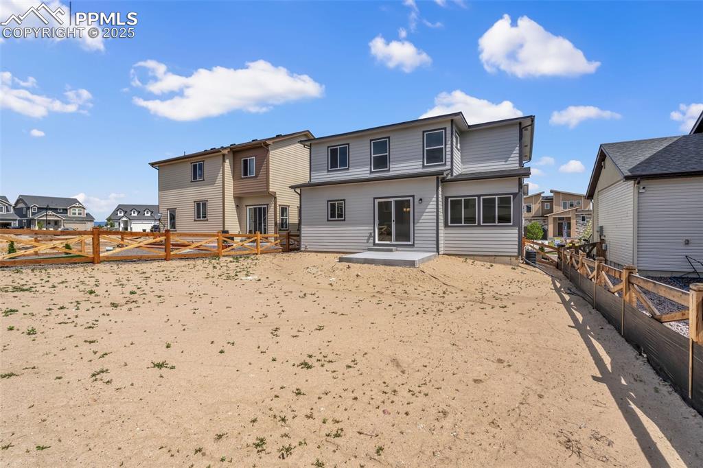 Image 39 of 43: Back of house featuring a fenced backyard, a patio area, and a residential 
