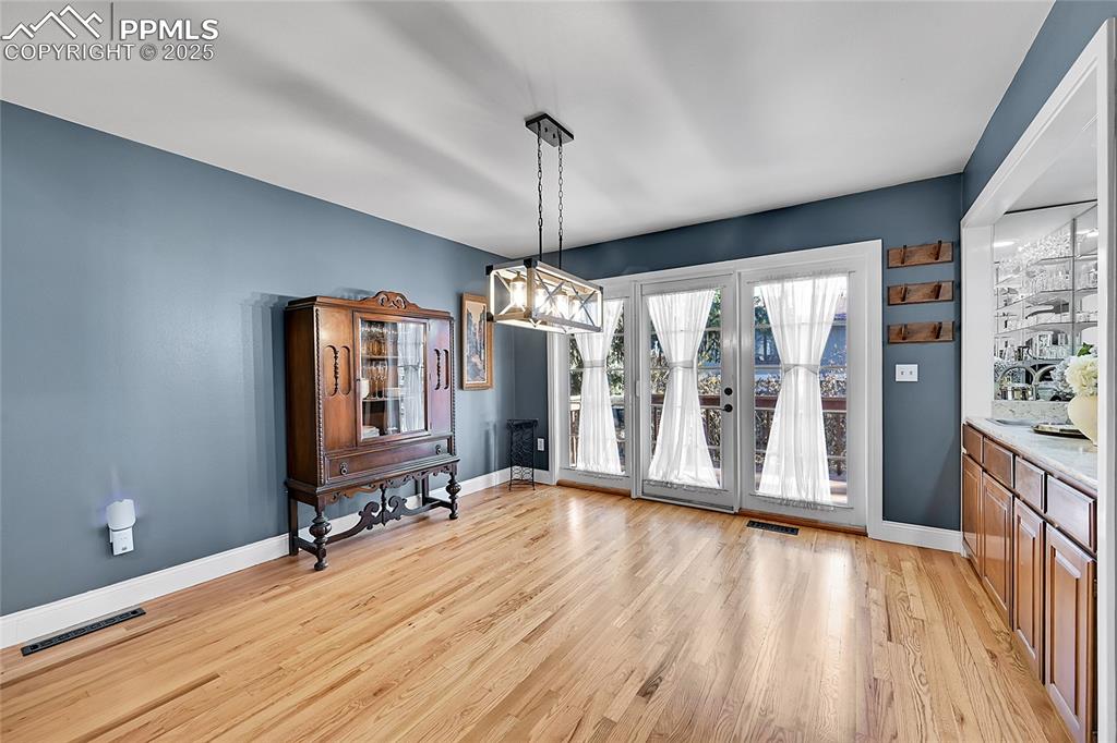 Image 10 of 43: Unfurnished dining area featuring light wood-type flooring and a chandelier
