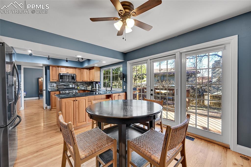 Image 15 of 43: Dining room with rail lighting, light wood finished floors, and a ceiling f