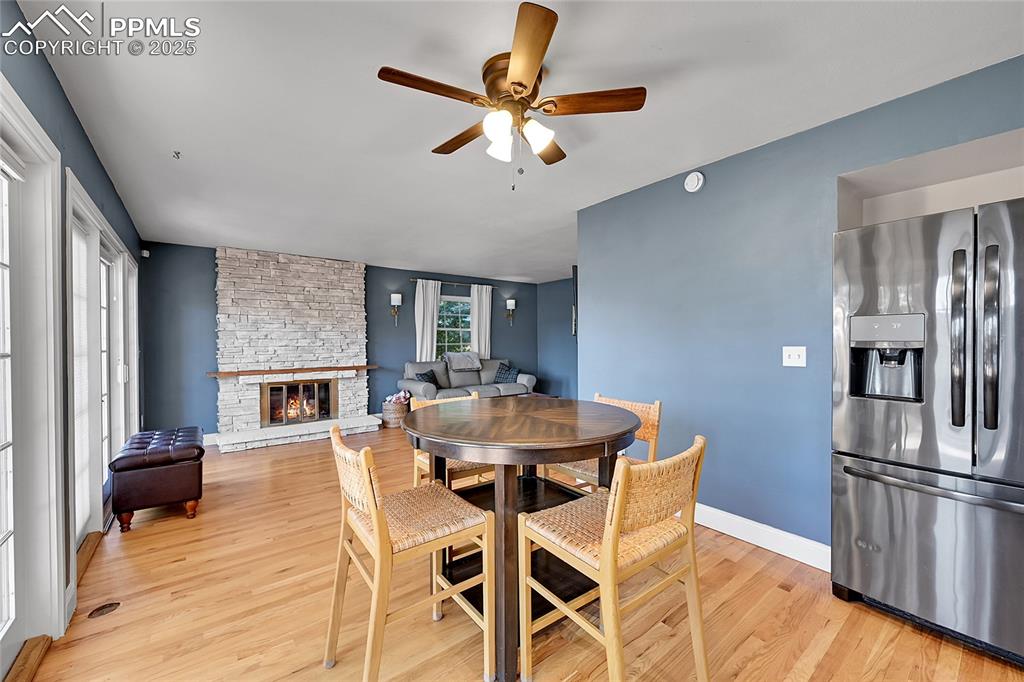 Image 16 of 43: Dining space featuring light wood-type flooring, a fireplace, and ceiling f