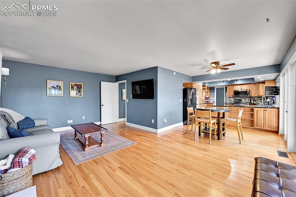 Image 17 of 43: Living area with light wood-type flooring and a ceiling fan