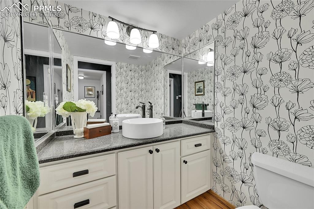 Image 20 of 43: Bathroom with vanity, light wood-style floors, and wallpapered walls