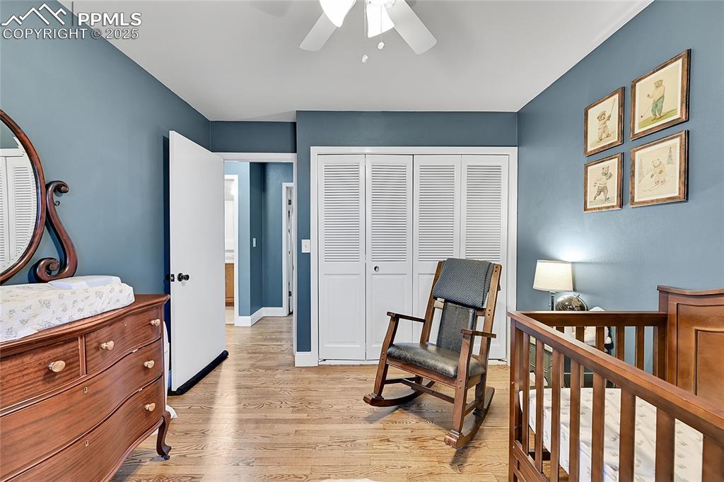 Image 30 of 43: Bedroom with a nursery area, a closet, light wood finished floors, and a ce