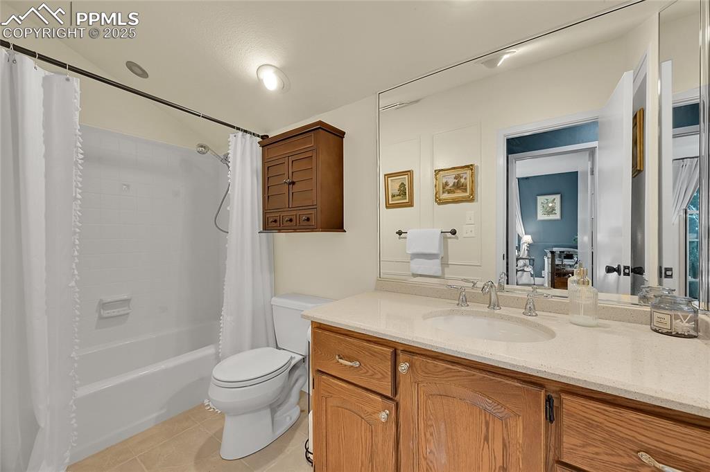 Image 31 of 43: Full bath featuring shower / bath combo, light tile patterned floors, and v