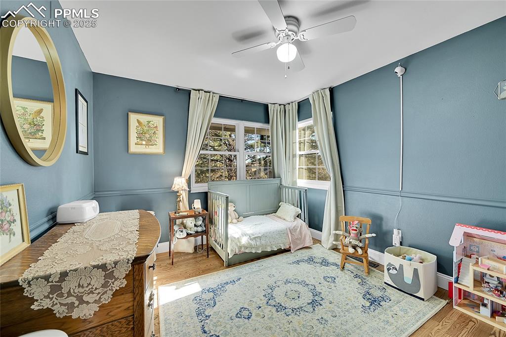 Image 32 of 43: Sitting room with wood finished floors and ceiling fan