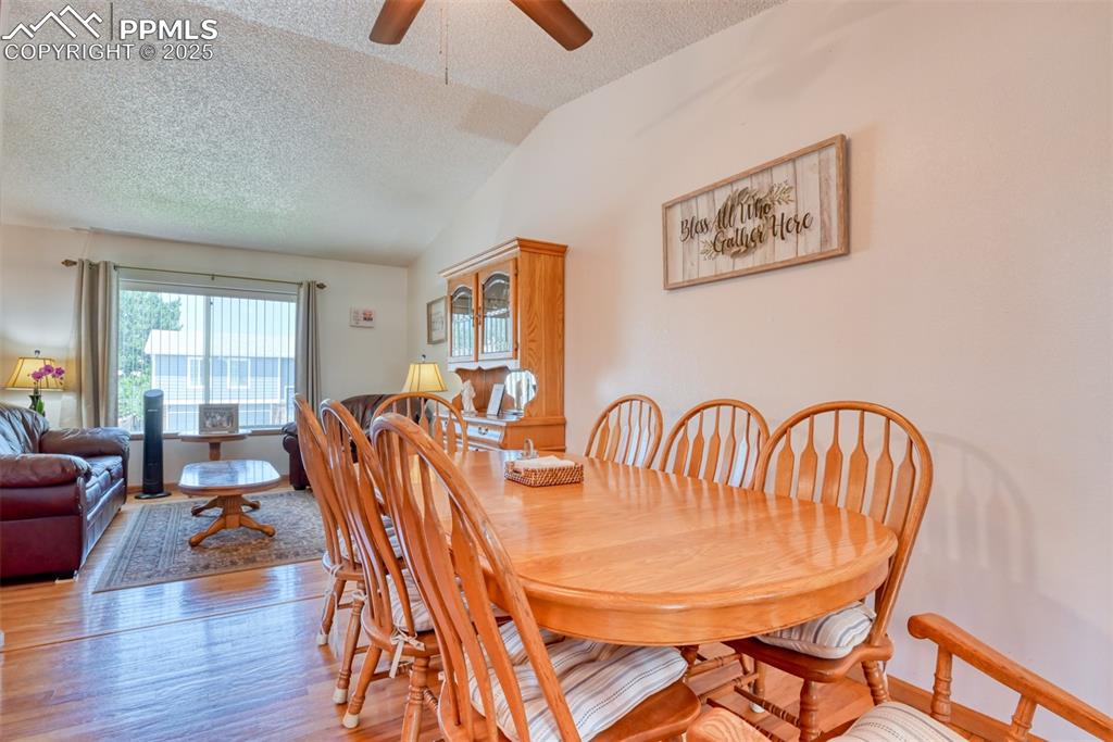 Image 10 of 46: Dining area featuring a textured ceiling, light wood finished floors, a cei