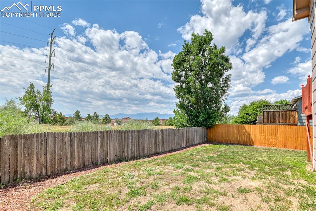 Image 22 of 46: Fenced backyard with a mountain view