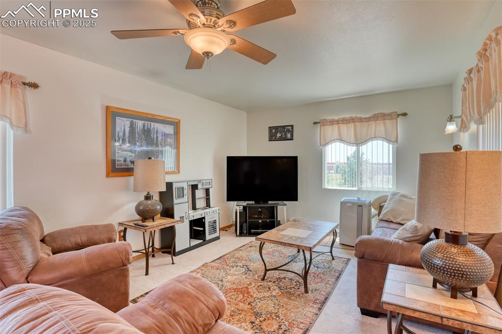 Image 25 of 46: Living area featuring carpet and ceiling fan