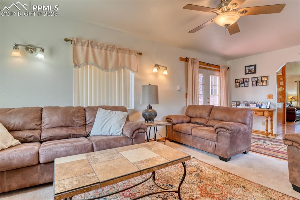 Image 27 of 46: Living room featuring arched walkways, carpet, and a ceiling fan