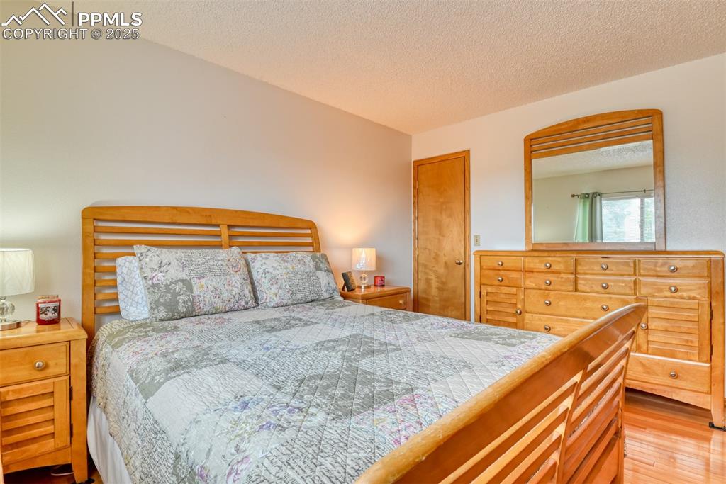 Image 32 of 46: Bedroom featuring wood finished floors and a textured ceiling