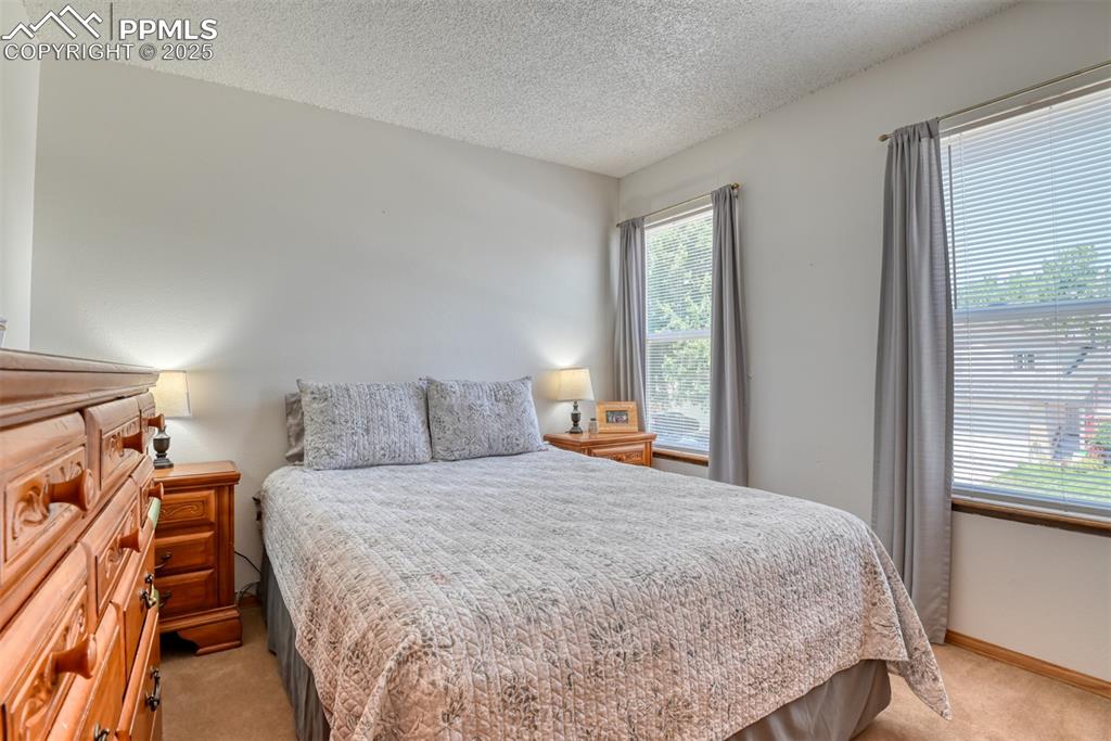 Image 35 of 46: Bedroom with light colored carpet and a textured ceiling