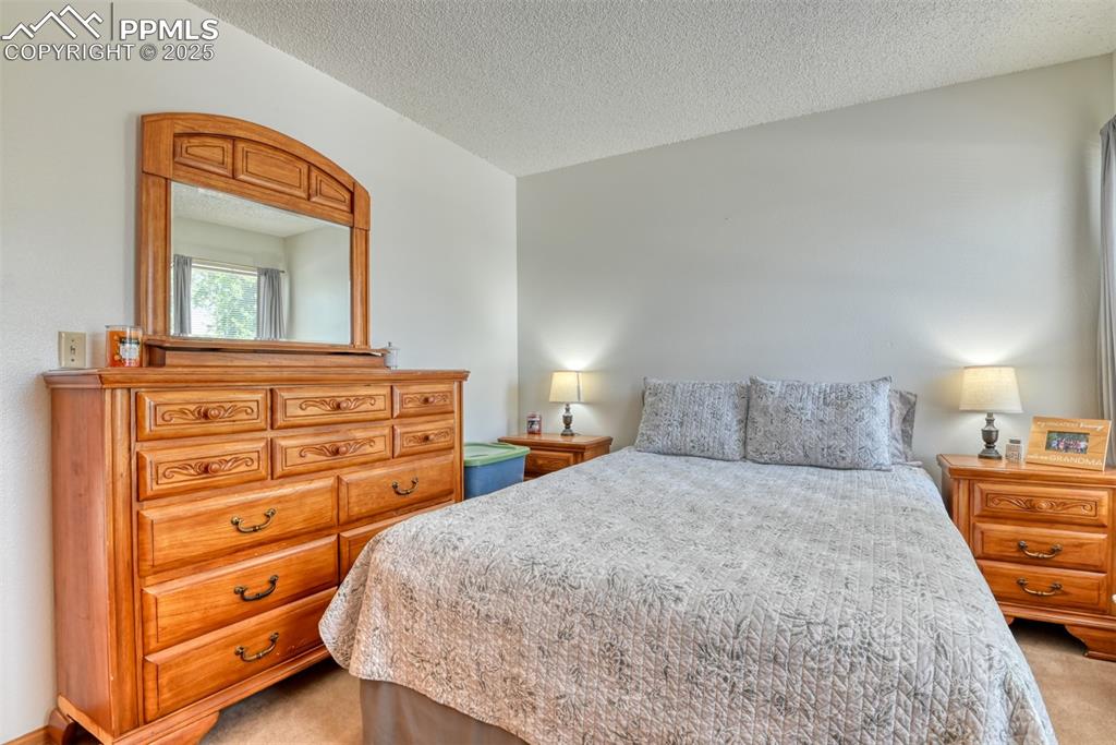 Image 36 of 46: Bedroom featuring light carpet and a textured ceiling