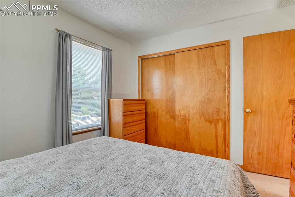 Image 38 of 46: Bedroom featuring a closet, carpet floors, and a textured ceiling