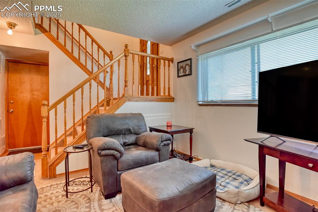 Image 41 of 46: Living area featuring stairway and a textured ceiling
