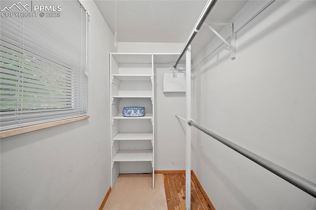 Image 18 of 41: Walk in closet with cedar flooring and large window.