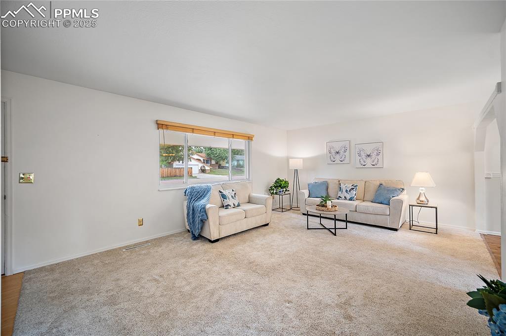 Image 4 of 41: Main level living room with large pitcure window and opent to the dining ro