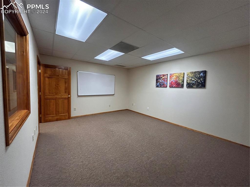 Image 21 of 45: Unfurnished room featuring carpet and a paneled ceiling