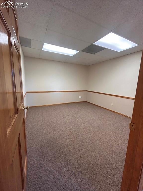 Image 27 of 45: Spare room featuring a paneled ceiling and carpet flooring