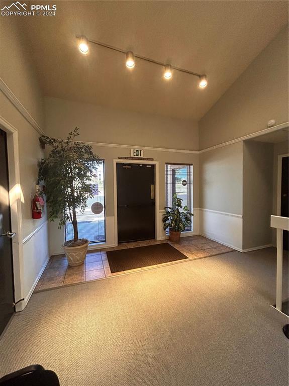 Image 39 of 45: Unfurnished living room with lofted ceiling and light colored carpet