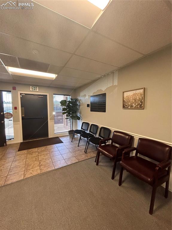 Image 48 of 49: Entryway with carpet floors and a drop ceiling