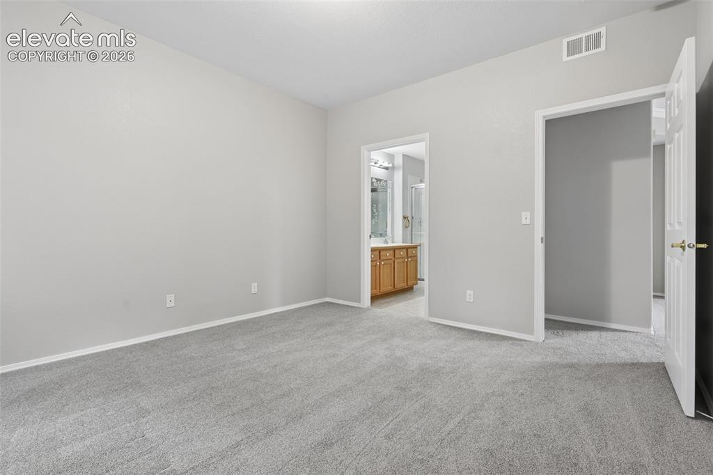 Image 12 of 27: Plush grey carpeting and light-toned wall finishes
