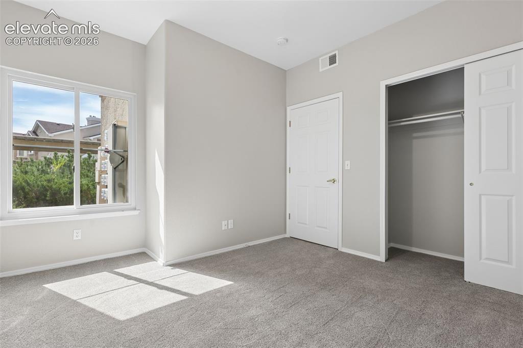 Image 13 of 27: Light gray carpeting, white trim, white sliding closet door, white raised p