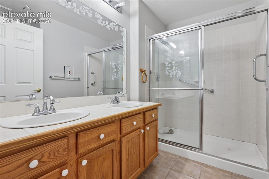 Image 15 of 27: Dual vanity with wood-finish cabinetry