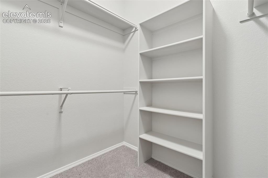 Image 16 of 27: Built-in shelving unit, dual clothing rods, and wall-mounted shelving