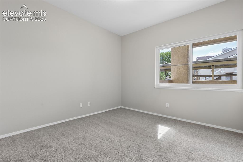 Image 18 of 27: Neutral-toned walls complement the gray carpeting