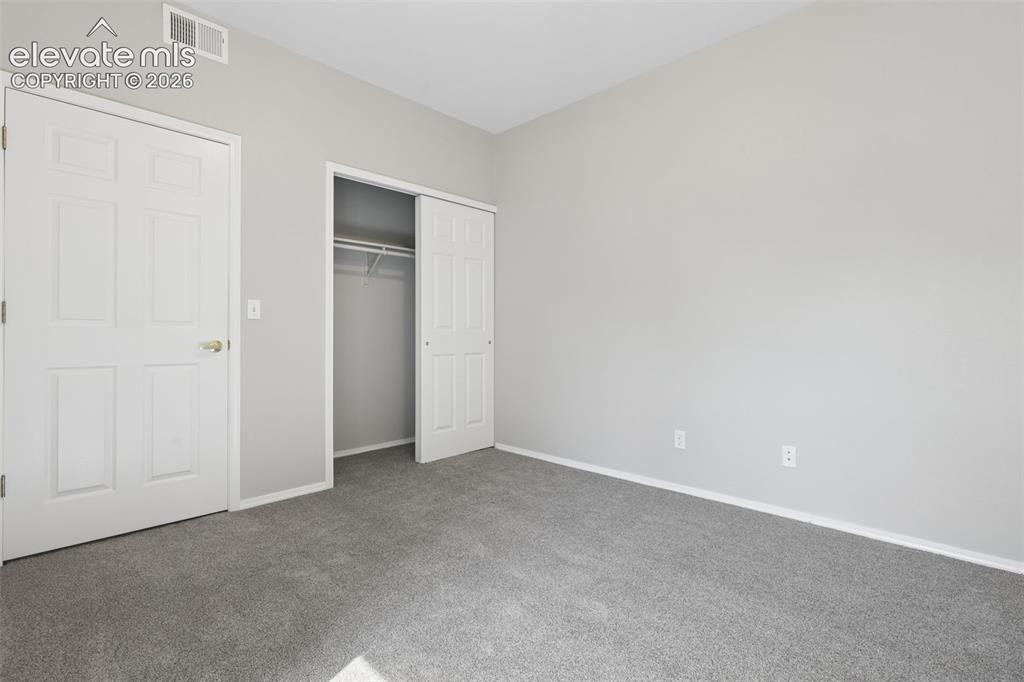 Image 20 of 27: Wall-to-wall carpeting, light gray wall paint, white trim, and a bi-fold cl