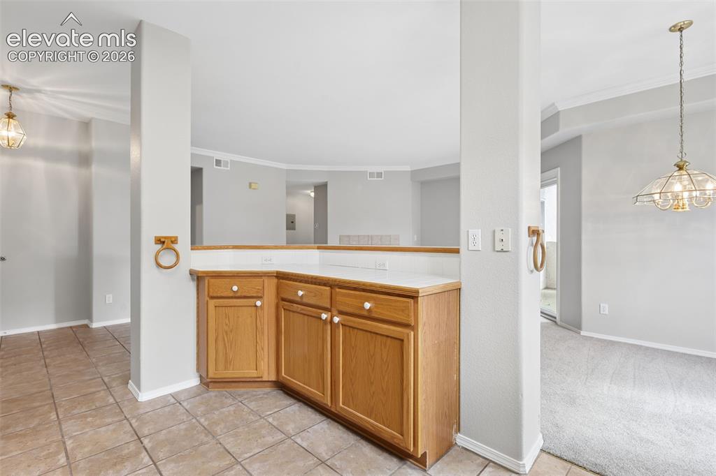 Image 8 of 27: Built-in cabinetry with light wood finish and white countertops