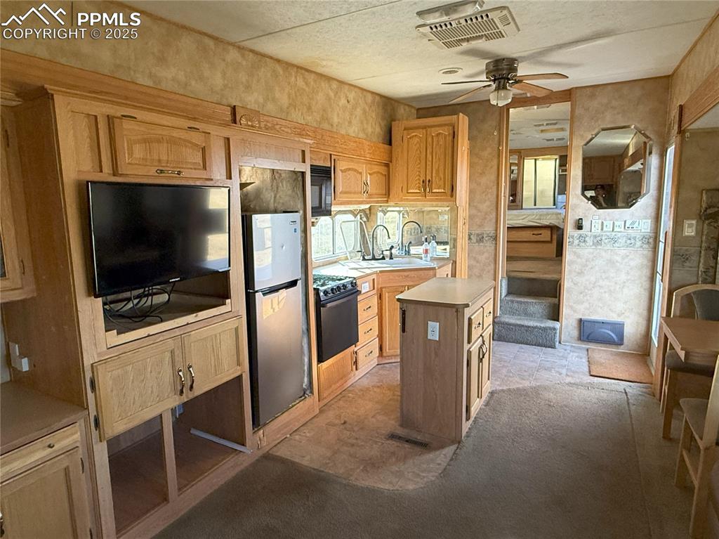 Image 12 of 15: Kitchen featuring light countertops, freestanding refrigerator, a ceiling f