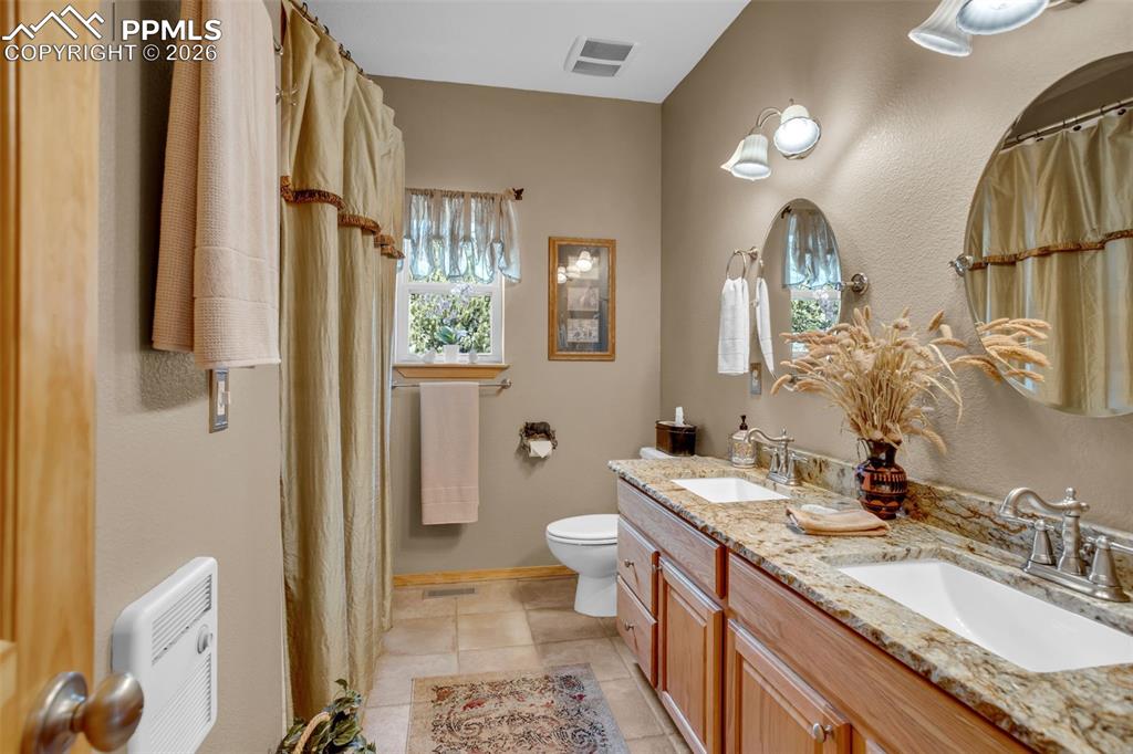 Image 19 of 44: Main level full bathroom with double vanities