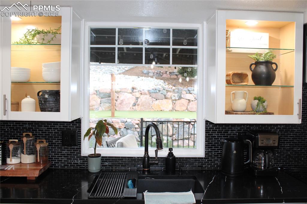 Image 10 of 26: Kitchen featuring tasteful backsplash, white cabinets, and healthy amount o
