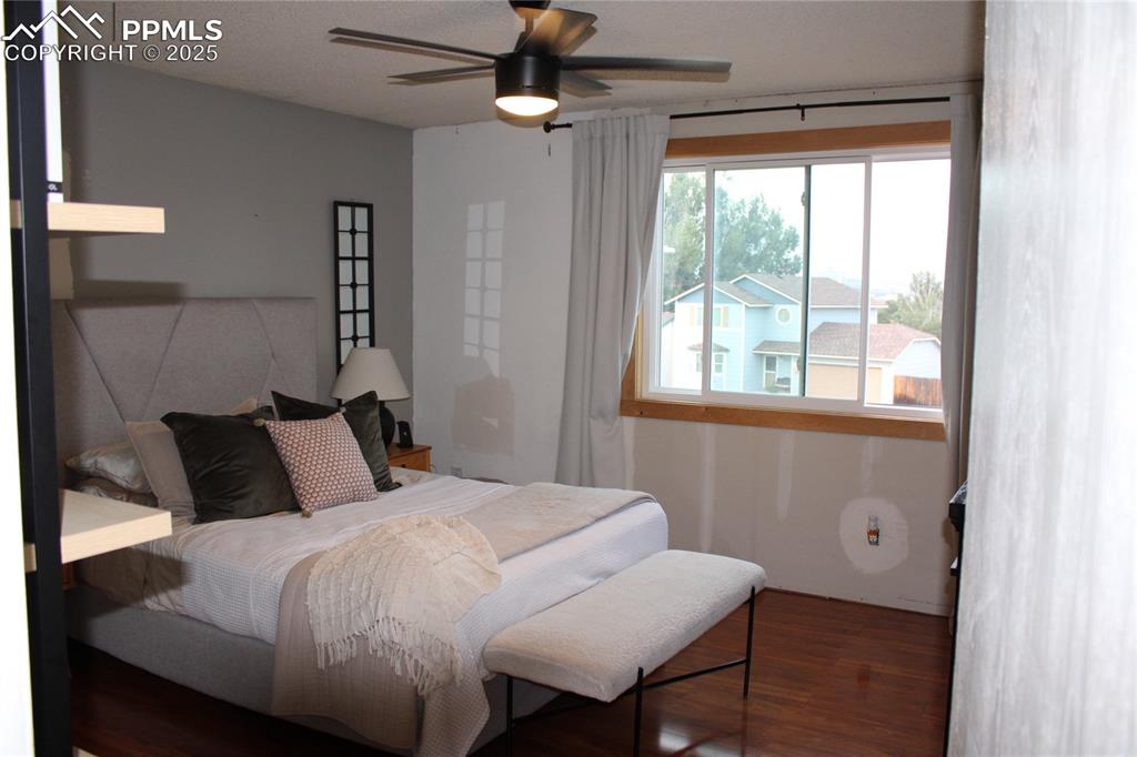 Image 13 of 26: Bedroom featuring wood finished floors and ceiling fan
