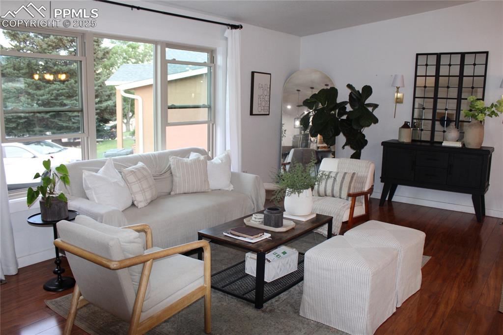 Image 6 of 26: Living room featuring wood finished floors and arched walkways