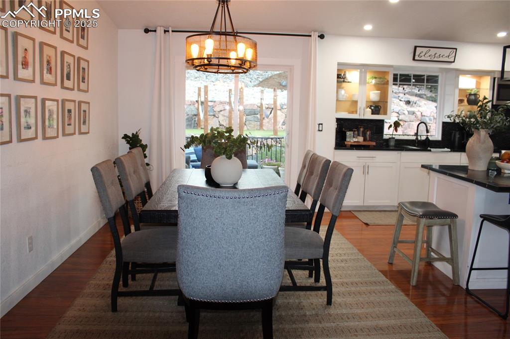Image 7 of 26: Dining space with dark wood-style floors, a chandelier, and recessed lighti
