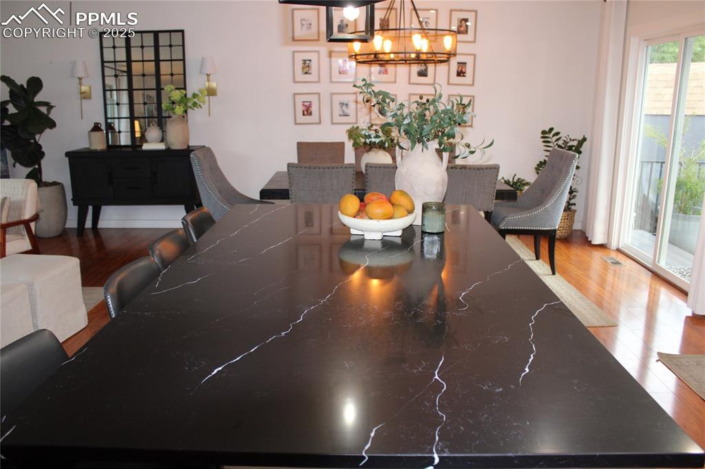 Image 8 of 26: Dining room featuring wood finished floors and a chandelier