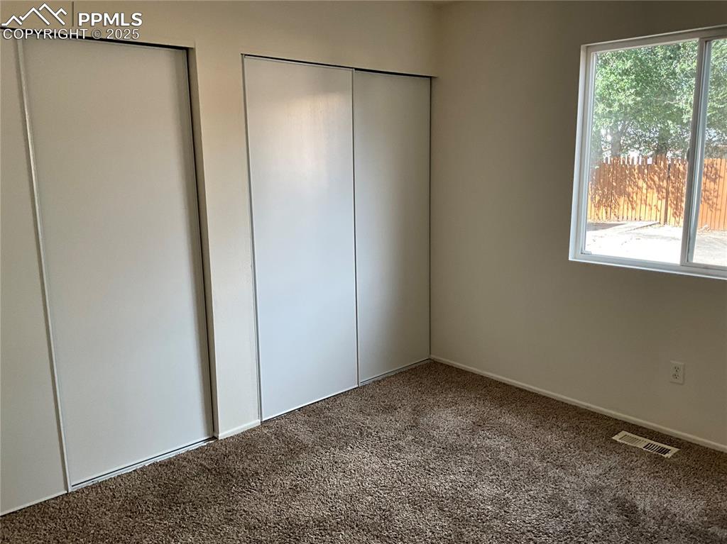 Image 10 of 13: Unfurnished bedroom with carpet and two closets