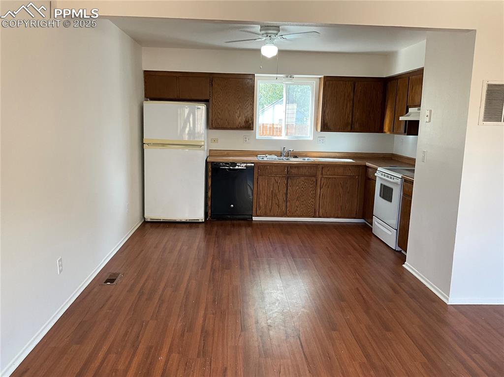 Image 7 of 13: Kitchen with white appliances, ceiling fan, dark wood-type flooring, under 
