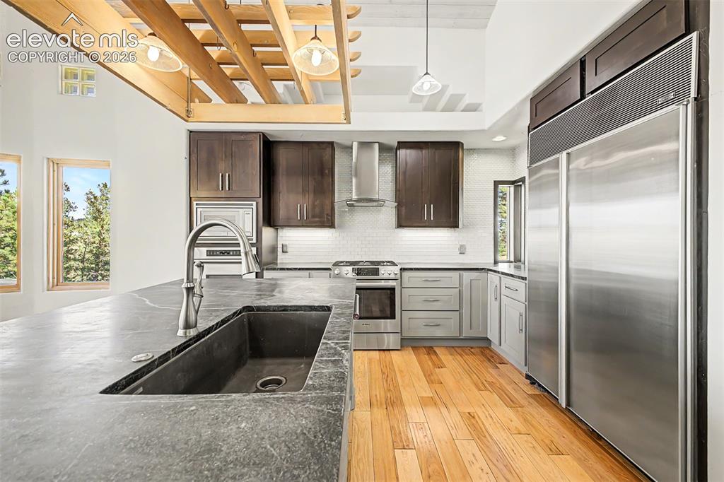 Image 16 of 50: Kitchen featuring a large island with an undermount sink and gooseneck fauc