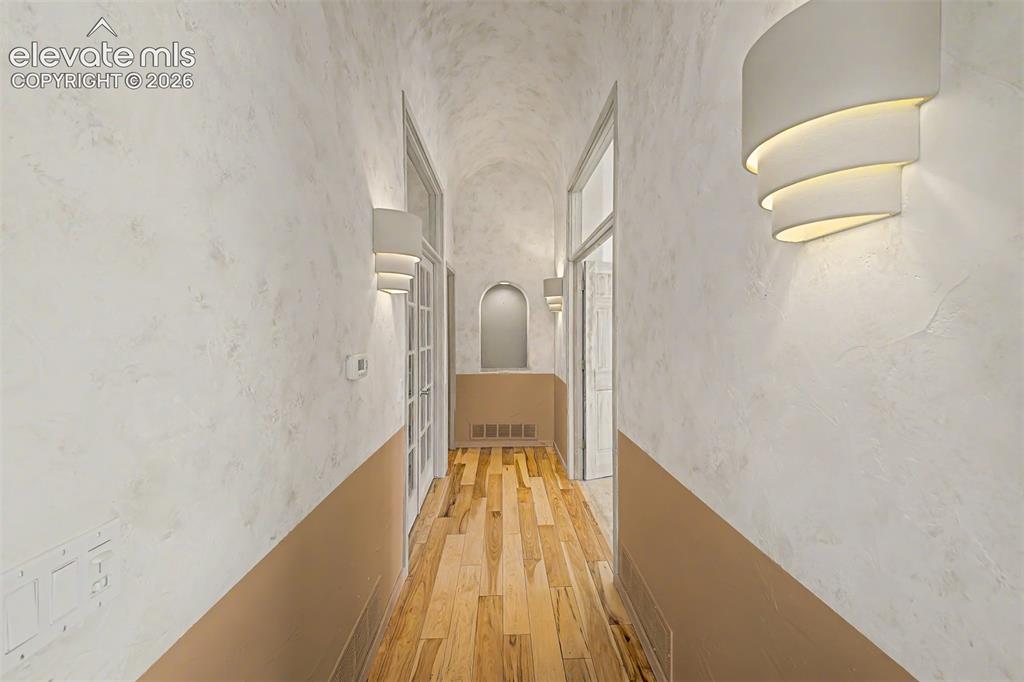 Image 22 of 50: Vaulted ceiling with textured finish, wood-finish flooring, and contemporar