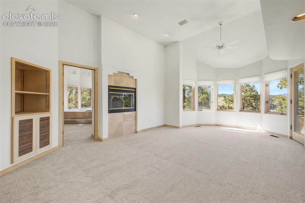 Image 25 of 50: Vaulted ceilings, a built-in fireplace with tile surround, an integrated ce