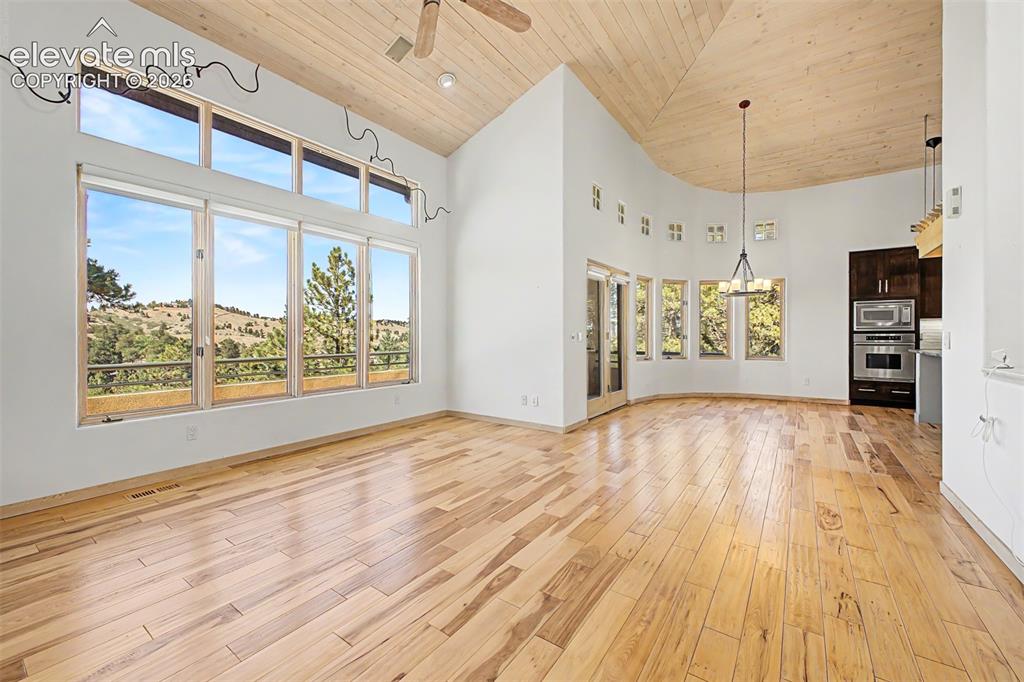 Image 9 of 50: Vaulted wood-paneled ceilings, expansive window wall with transoms, wood-fi