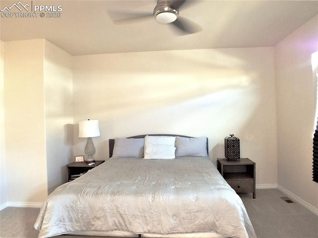 Image 17 of 46: Primary Bedroom with Plantation Shutters and Fan