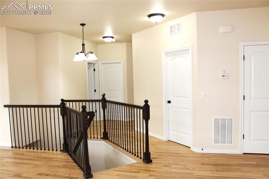 Image 9 of 46: Wrought Iron with Wood Rail Stairway to Basement